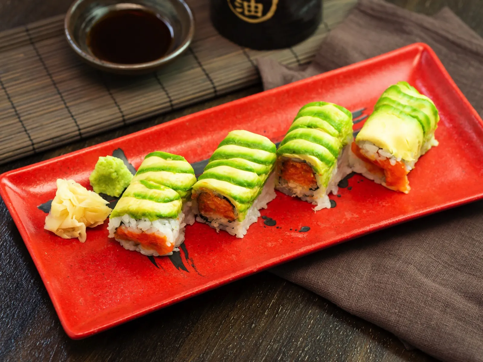 Avocado-wrapped roll on a red plate at Kikoo Sushi