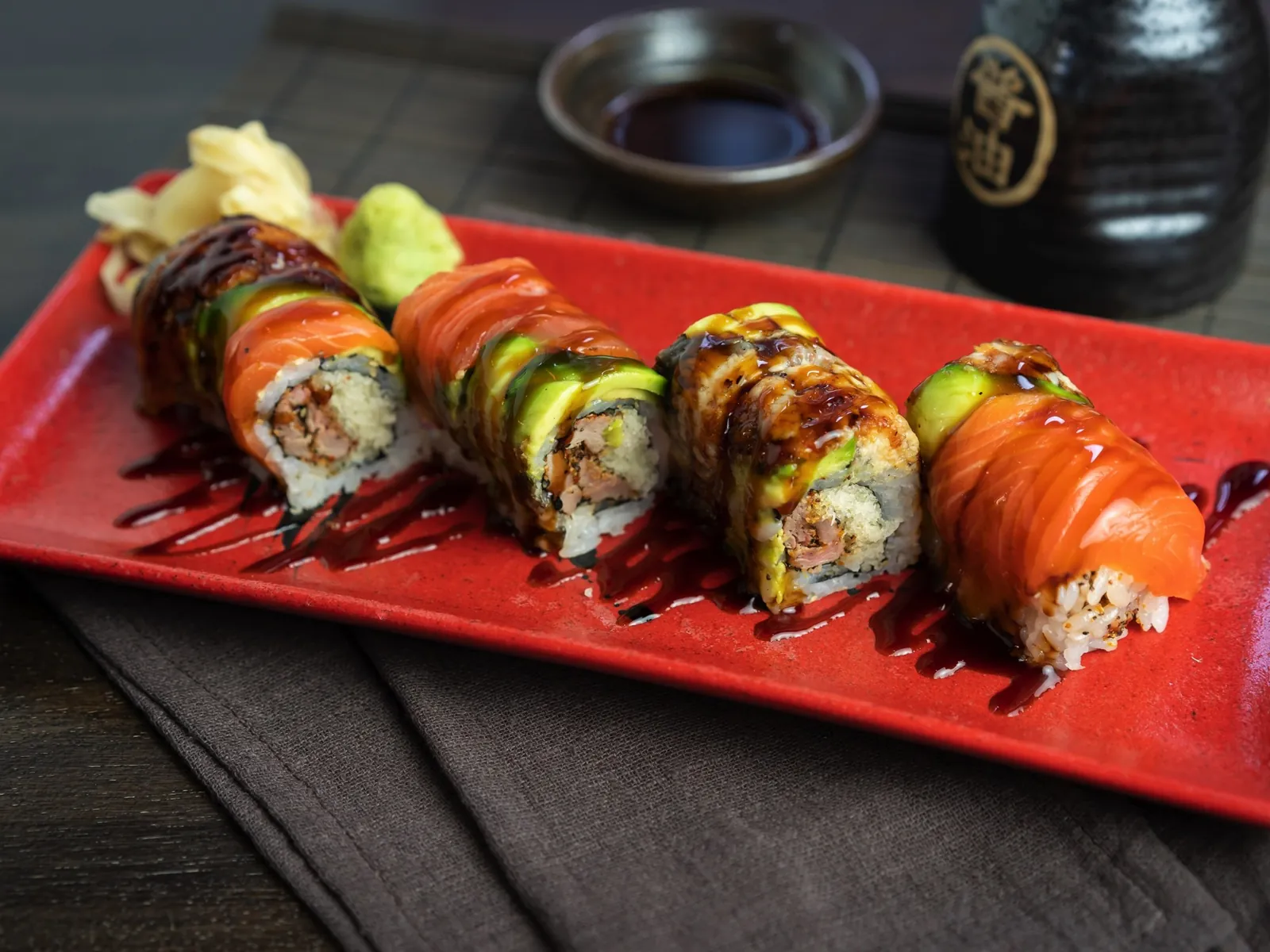 Salmon-wrapped roll on a red plate at Kikoo Sushi